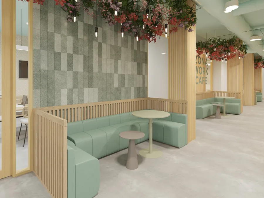 Zona de work café con los bancos verdes y las mesas redondas