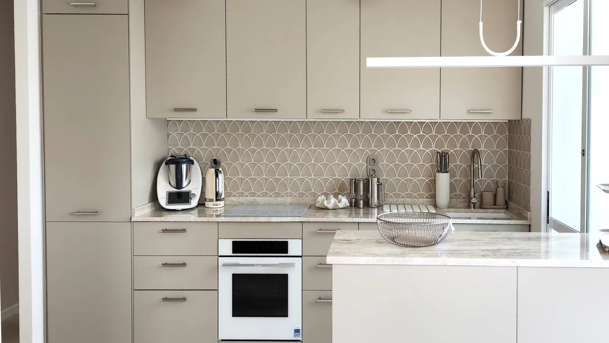 Cocina reformada con frente de azulejo escamado y lámparas colgantes