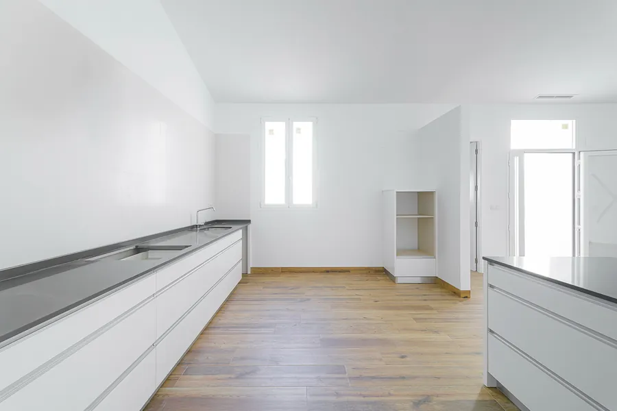 Cocina en blanco abierta al espacio central